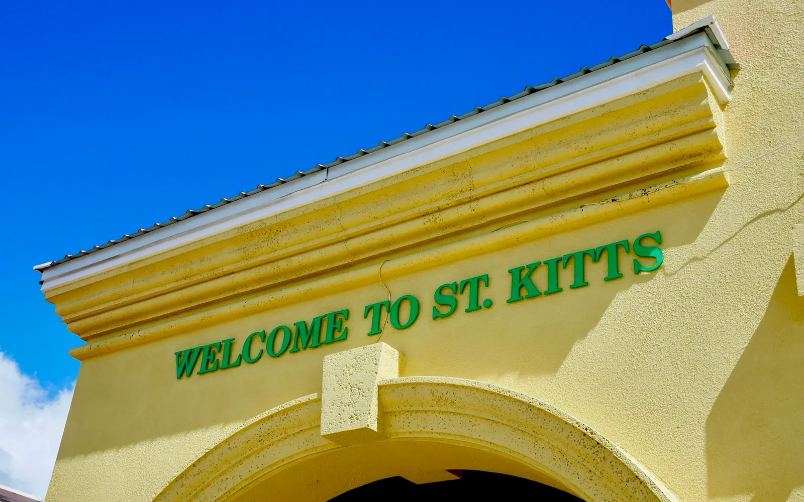 Welcome to St. Kitts sign on a yellow archway